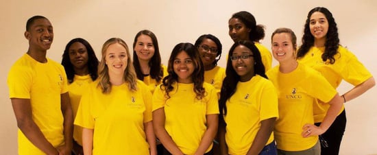 UNCG team in yellow shirts.